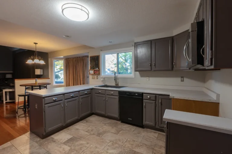 Before view of a segmented kitchen layout in Parker, CO with a peninsula and dark cabinetry prior to island installation.
