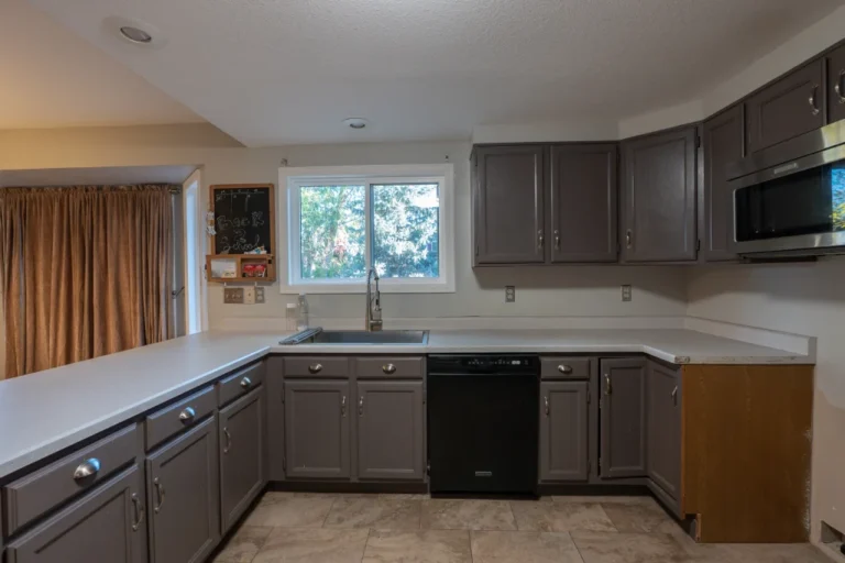Dated kitchen in Parker, CO 80138 showing dark painted cabinets and laminate countertops before a luxury remodel.