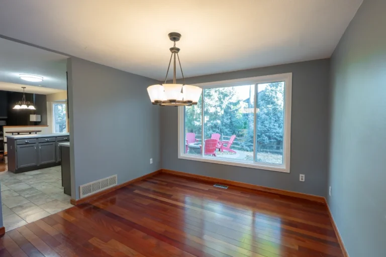 Before view of a compartmentalized dining room and dated kitchen in Parker, CO, separated by a structural wall prior to renovation.