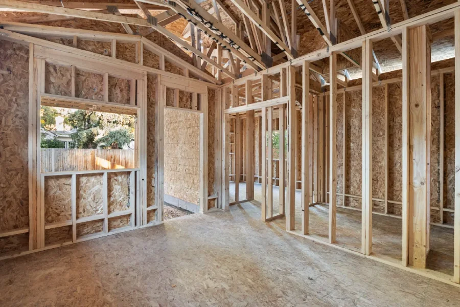 Interior wood framing of a second-story pop-top addition at a home on S Bemis St, Littleton, CO. The image shows new load-bearing walls and roof trusses during the structural construction phase of a vertical expansion.