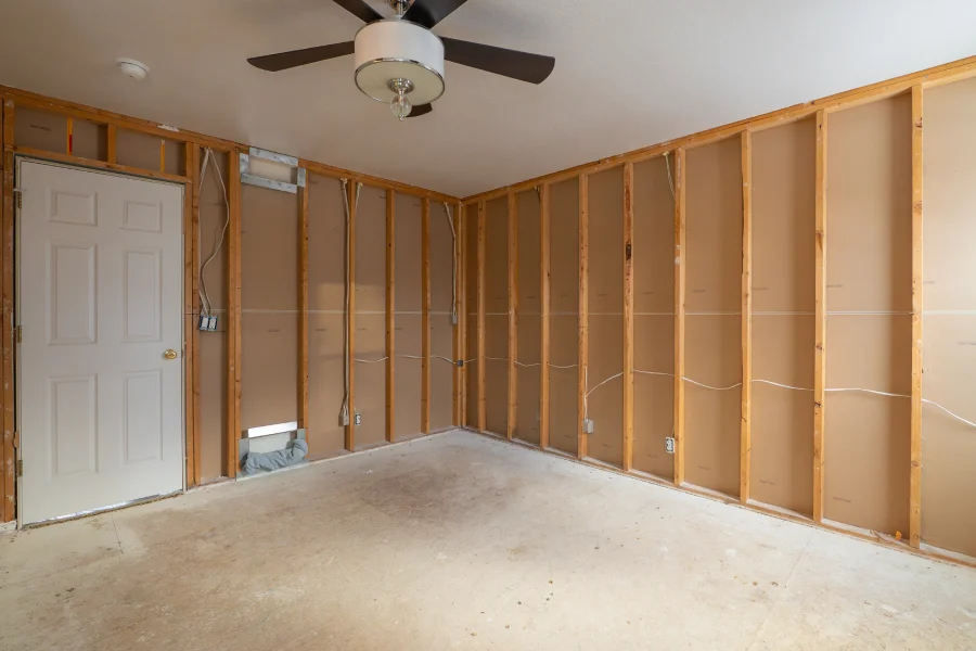 Before photo of a master bedroom renovation in Northglenn, CO 80233. The room is gutted to the studs to install ROCKWOOL R23 soundproof insulation before installing new LVP flooring.