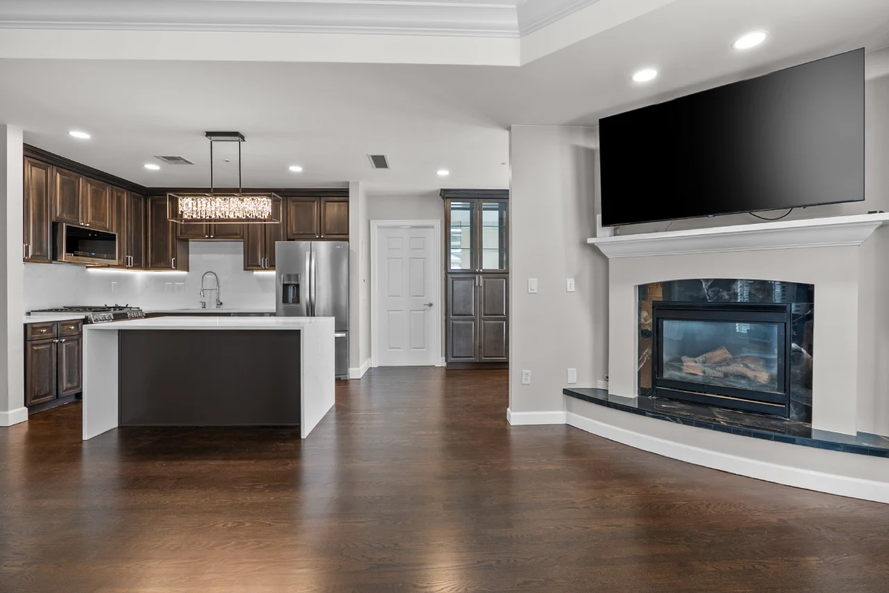 Open-concept kitchen and living room in a Denver full home remodel with quartz island and redesigned fireplace