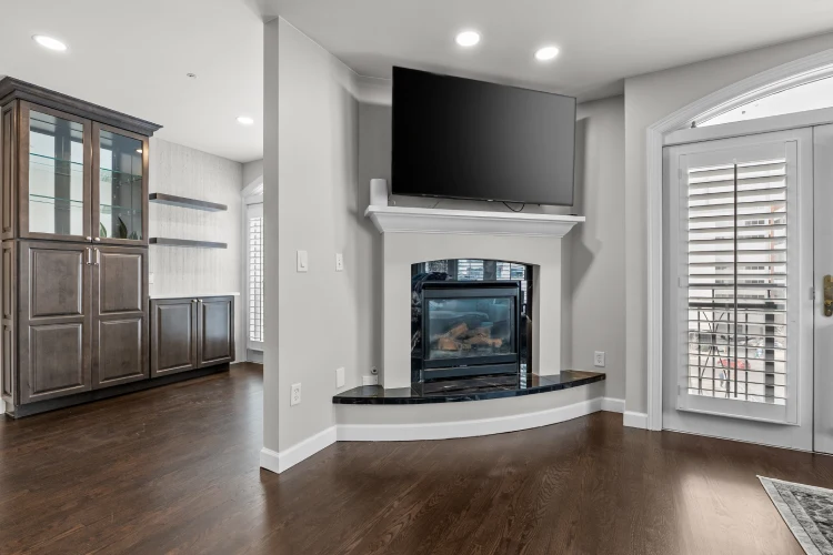 Living room fireplace remodel in Denver with dark tile surround, curved hearth, and adjacent custom built-in