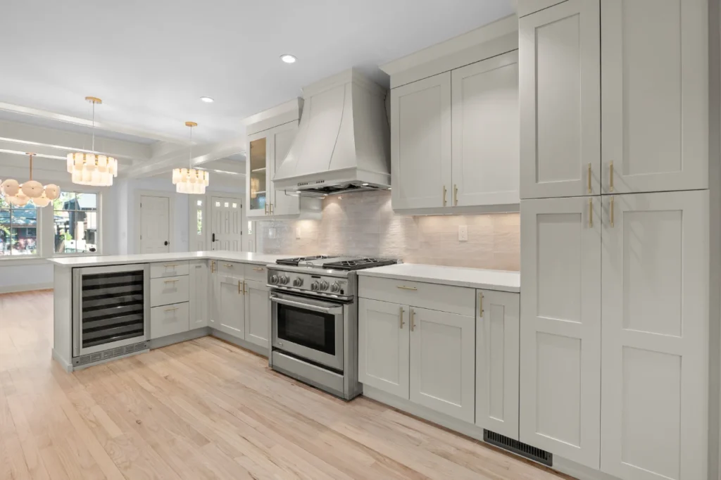 Custom Kashmir by Portola Paints kitchen with sculptural hood cover, Miele range, and brushed brass hardware in Wash Park renovation