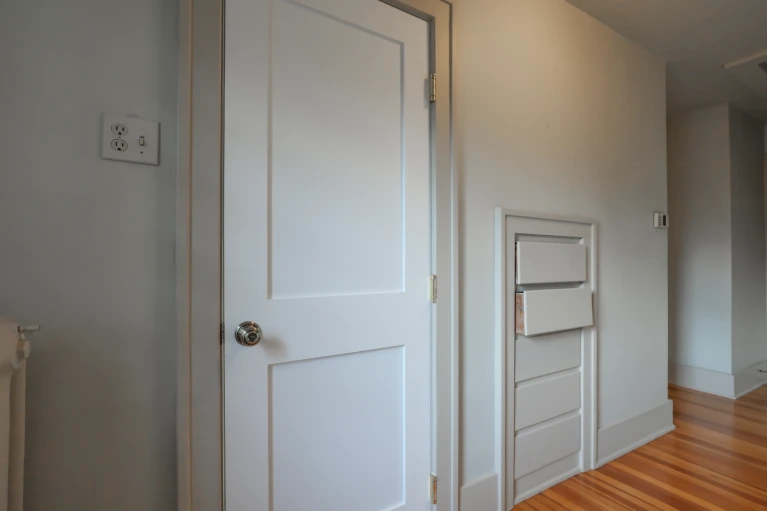 Hallway entry to the existing powder room and adjacent closet before the bathroom conversion.