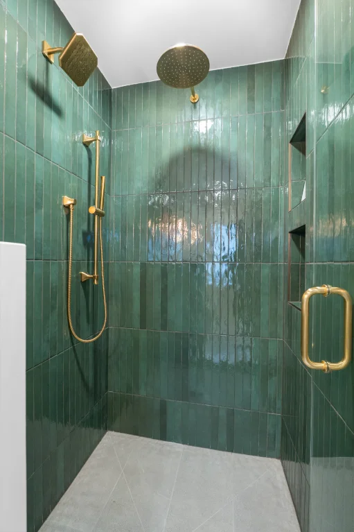 New full bathroom with walk-in shower, wood vanity, and toilet, completed in a Denver powder room conversion.