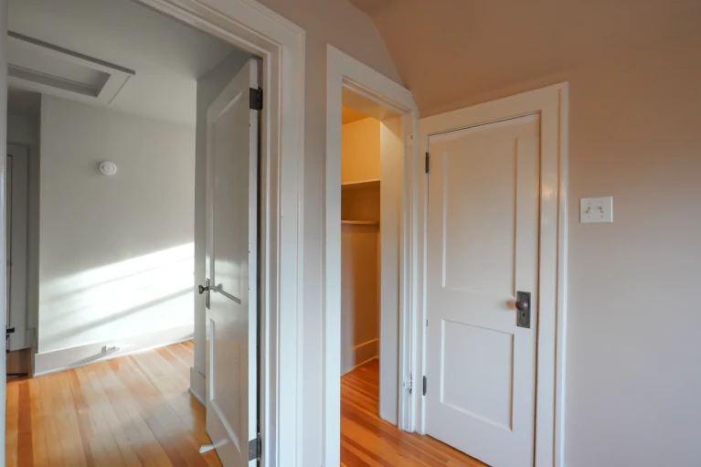 Original hallway showing the powder room and closet doorways before the bathroom conversion in West Highland Denver.