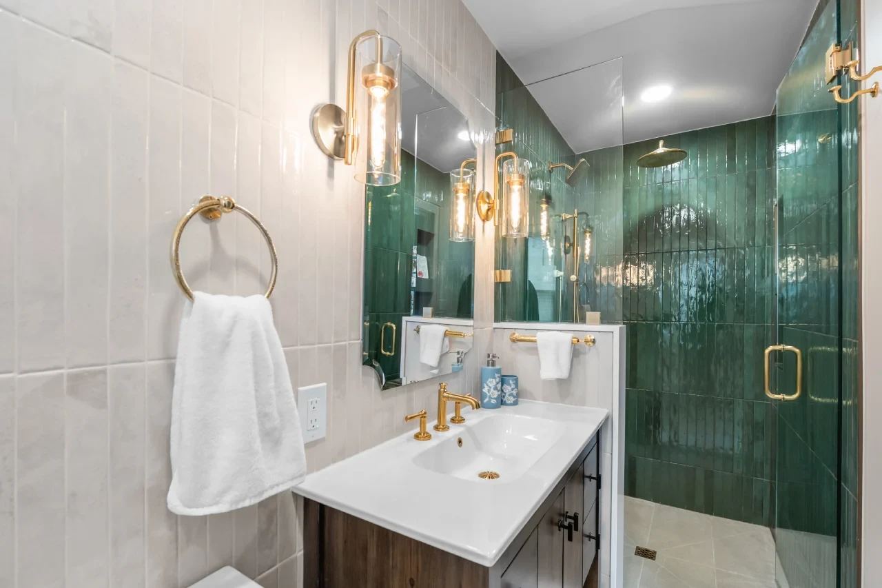 Powder room converted to a full bath with walk-in shower, green Forest porcelain tile, brass Kohler fixtures, in Denver.