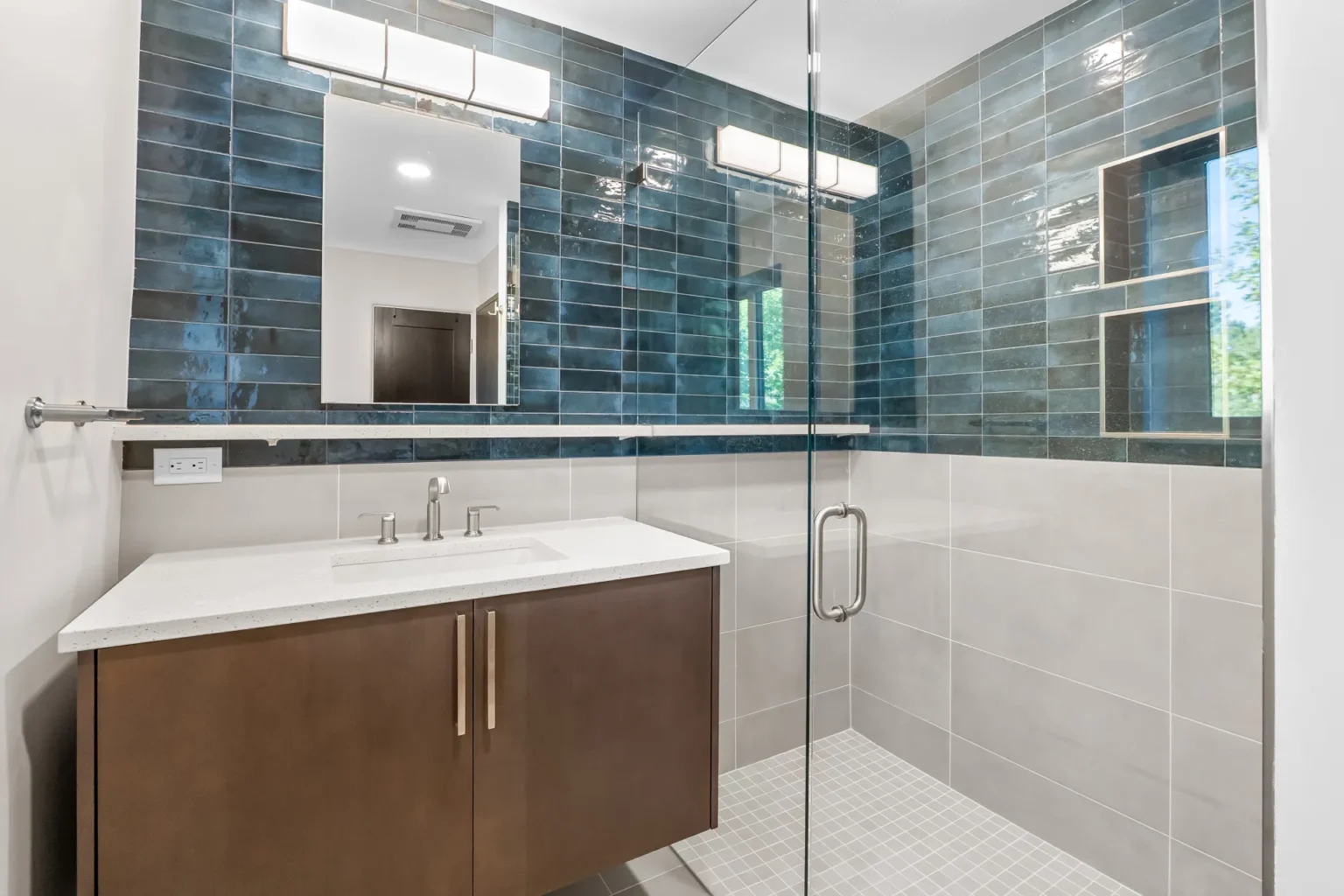Finished Park Hill kids' bathroom after tub-to-curbless-shower conversion with floating vanity and Mir Moda blue tile