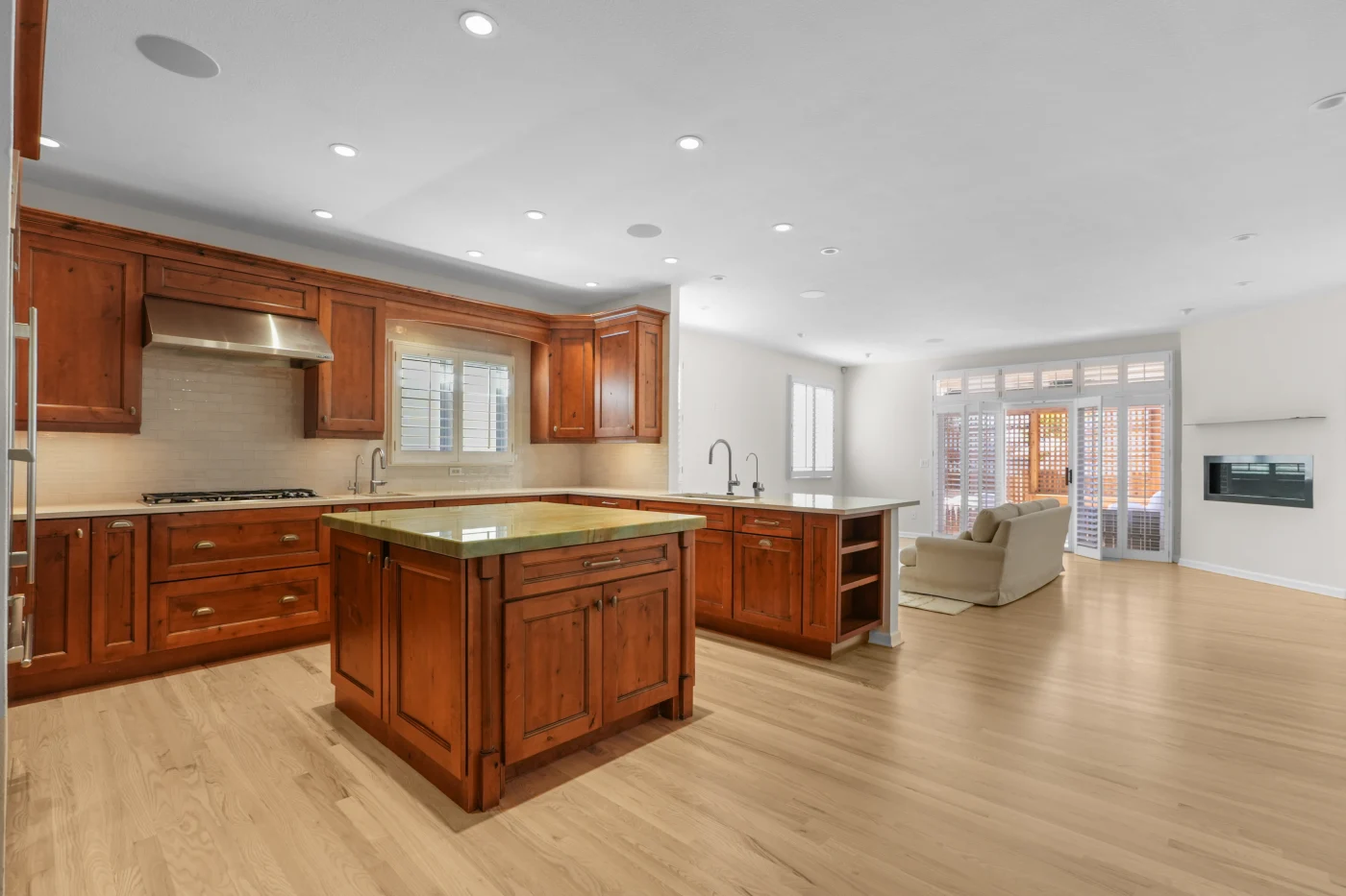 Kitchen island and cherry cabinetry seen from the dining side, with recessed lighting overhead